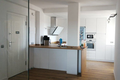 Imagen de cocinas en U pequeño abierto con fregadero bajoencimera, encimera de laminado, electrodomésticos de acero inoxidable, suelo laminado y encimeras marrones
