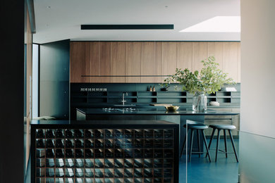 Design ideas for an expansive contemporary single-wall open plan kitchen with an integrated sink, flat-panel cabinets, dark wood cabinets, marble benchtops, concrete floors and with island.