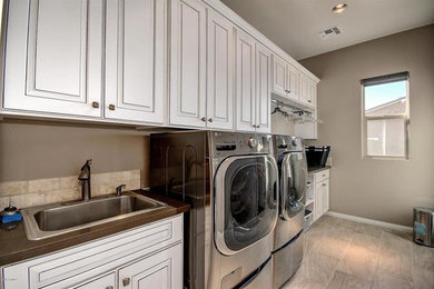 Large elegant galley dedicated laundry room photo in Phoenix with a drop-in sink, raised-panel cabinets, white cabinets, a side-by-side washer/dryer and quartzite countertops