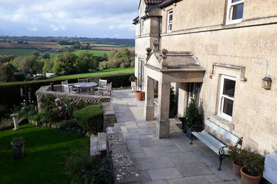 This is an example of a medium sized rural front formal full sun garden in West Midlands with concrete paving.