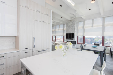 Inspiration for a large modern l-shaped cement tile floor and gray floor eat-in kitchen remodel in New York with an undermount sink, flat-panel cabinets, white cabinets, quartz countertops, white backsplash, limestone backsplash, paneled appliances, an island and white countertops