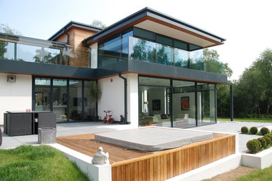 Large contemporary two-storey stucco white house exterior in Berkshire with a metal roof.