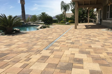 This is an example of a traditional drought-tolerant backyard concrete paver water fountain landscape in San Diego.