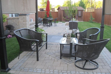 Inspiration for a timeless backyard brick patio remodel in Toronto with a pergola