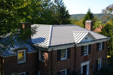 Example of a large classic red two-story brick exterior home design in Columbus with a hip roof