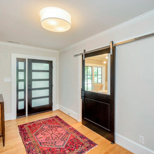 Réalisation d'une porte d'entrée bohème de taille moyenne avec un mur beige, un sol en bois clair, une porte simple, une porte en verre et un sol marron.