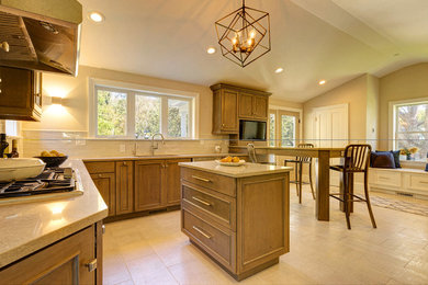 Kitchen - mid-sized transitional porcelain tile and gray floor kitchen idea in New York with an undermount sink, recessed-panel cabinets, gray cabinets, quartz countertops, beige backsplash, ceramic backsplash, stainless steel appliances, a peninsula and beige countertops