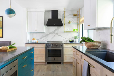 Mid-sized trendy u-shaped medium tone wood floor and brown floor eat-in kitchen photo in San Francisco with an undermount sink, flat-panel cabinets, blue cabinets, soapstone countertops, white backsplash, porcelain backsplash, stainless steel appliances, a peninsula and black countertops