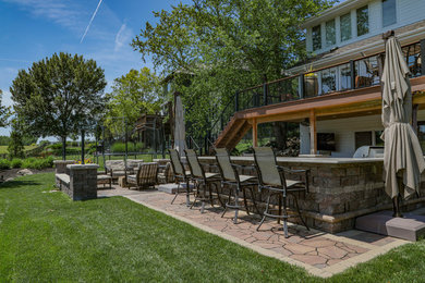 Mid-sized trendy backyard concrete paver patio kitchen photo in Omaha