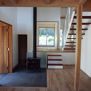 東京都下の片開きドアカントリー風おしゃれな玄関ホール (白い壁、コンクリートの床、木目調のドア、黒い床) の写真