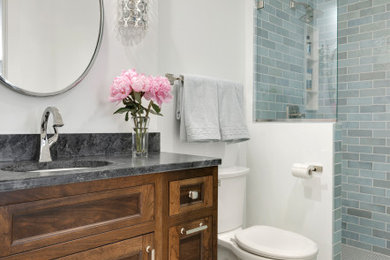 Inspiration for a small transitional 3/4 blue tile ceramic tile, white floor and single-sink bathroom remodel in Minneapolis with recessed-panel cabinets, dark wood cabinets, white walls, an undermount sink, soapstone countertops, black countertops and a built-in vanity