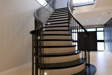 Curved cut string staircase with metal balustrade