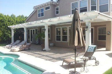 Patio - large traditional backyard concrete patio idea in Los Angeles with a pergola