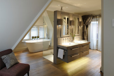 Design ideas for a mid-sized contemporary master bathroom in London with furniture-like cabinets, grey cabinets, a freestanding tub, an open shower, a wall-mount toilet, medium hardwood floors, a vessel sink and marble benchtops.