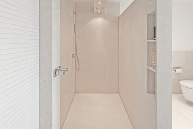 Photo of an expansive contemporary bathroom in Other with beige cabinets, a curbless shower, beige tile, stone slab, beige walls, granite benchtops and beige floor.