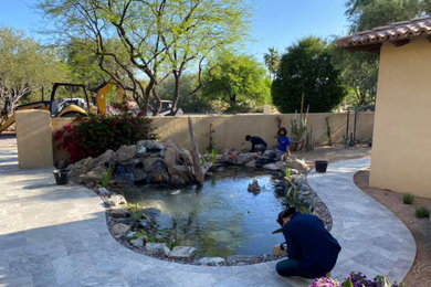 This is an example of a mediterranean full sun courtyard pond in Phoenix.