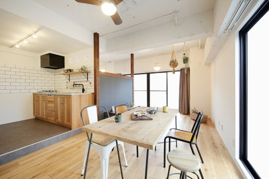 Design ideas for an industrial dining room in Nagoya with white walls, light hardwood floors and brown floor.