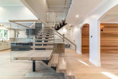 Transitional wooden floating glass railing staircase photo in San Francisco with wooden risers