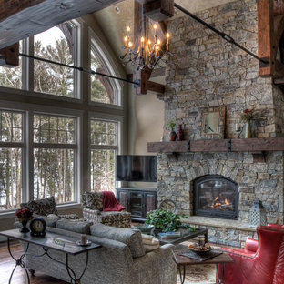 Imagen de salón para visitas rural con chimenea tradicional y marco de chimenea de piedra