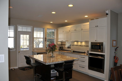 Inspiration for a contemporary kitchen remodel in DC Metro with an undermount sink, shaker cabinets, white cabinets, granite countertops, stainless steel appliances, an island and beige countertops