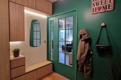 Exemple d'un petit hall d'entrée tendance en bois avec un mur vert, parquet clair, une porte double, une porte verte et un sol beige.