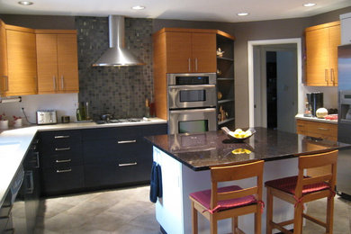 Enclosed kitchen - large modern u-shaped gray floor enclosed kitchen idea in Albuquerque with an undermount sink, flat-panel cabinets, medium tone wood cabinets, quartz countertops, gray backsplash, glass tile backsplash, stainless steel appliances and an island