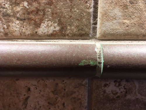 Builder selected inexpensive pencil tile trim....green color showing