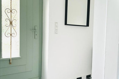 Kleiner Moderner Schmaler Flur mit weißer Wandfarbe, Porzellan-Bodenfliesen und schwarzem Boden in Berlin