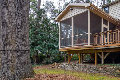 This is an example of a small transitional screened-in and mixed material railing back porch design in Raleigh with decking and a roof extension.