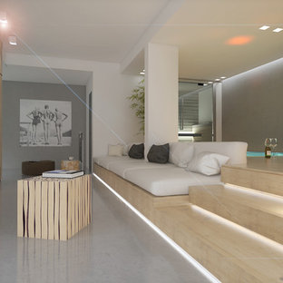 Idée de décoration pour une très grande salle de cinéma design ouverte avec un mur blanc, béton au sol, un téléviseur encastré et un sol gris.