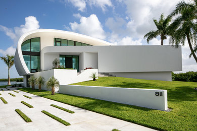 Contemporary white three-story house exterior idea in Tampa with a white roof