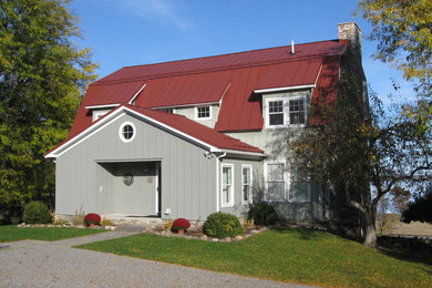 This is an example of a large country three-storey green exterior in New York with mixed siding and a gambrel roof.