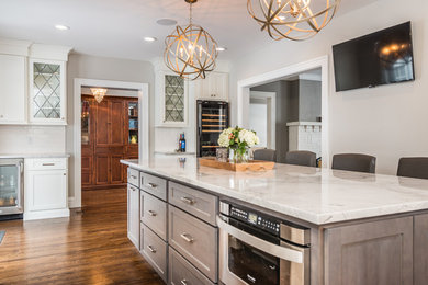 Eat-in kitchen - mid-sized modern u-shaped medium tone wood floor eat-in kitchen idea in St Louis with an undermount sink, recessed-panel cabinets, white cabinets, granite countertops, white backsplash, subway tile backsplash, stainless steel appliances and an island