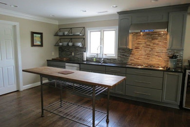 Inspiration for a large transitional dark wood floor and brown floor kitchen remodel in San Diego with a double-bowl sink, recessed-panel cabinets, gray cabinets, granite countertops, multicolored backsplash, stone tile backsplash, stainless steel appliances and two islands