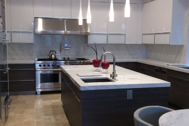 Design ideas for a large modern u-shaped kitchen in Los Angeles with an undermount sink, flat-panel cabinets, white cabinets, marble benchtops, white splashback, stone slab splashback, stainless steel appliances, ceramic floors and with island.