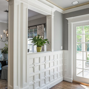 Photo of a large traditional open concept home theatre in Providence with grey walls, medium hardwood floors and a wall-mounted tv.