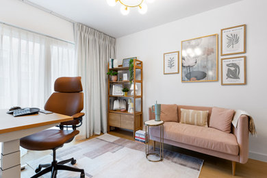 Photo of a large modern study in London with white walls, no fireplace and a freestanding desk.