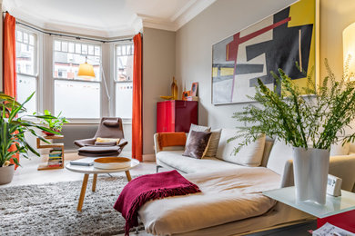 Inspiration for a small midcentury open plan living room in London with beige walls, light hardwood flooring, no fireplace, a freestanding tv and white floors.