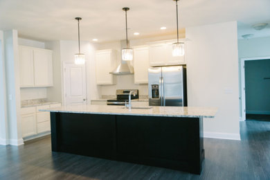 Inspiration for a mid-sized transitional l-shaped dark wood floor and black floor open concept kitchen remodel in Chicago with an undermount sink, recessed-panel cabinets, white cabinets, granite countertops, stainless steel appliances and an island