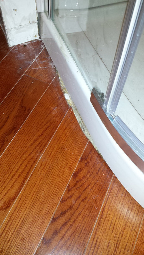 Fill gap between shower base and hardwood floor?