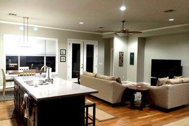 Inspiration for a mid-sized modern u-shaped light wood floor and brown floor eat-in kitchen remodel in Phoenix with an undermount sink, glass-front cabinets, black cabinets, quartz countertops, metallic backsplash, mosaic tile backsplash, stainless steel appliances, an island and white countertops
