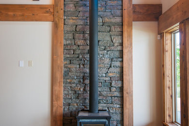 Inspiration for a mid-sized craftsman living room remodel in Vancouver with a wood stove, a stone fireplace and white walls