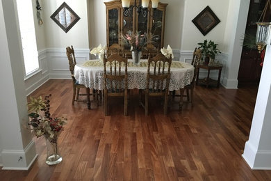 Example of a mid-sized classic dark wood floor and brown floor enclosed dining room design in Raleigh with beige walls and no fireplace