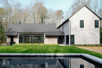 Inspiration for a large farmhouse beige two-story wood exterior home remodel in Chicago with a shingle roof and a black roof