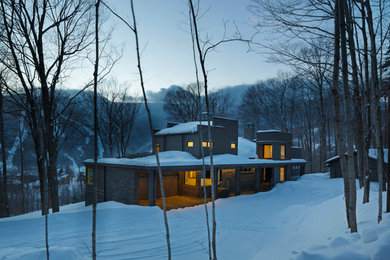 Large trendy gray two-story mixed siding house exterior photo in Burlington with a tile roof