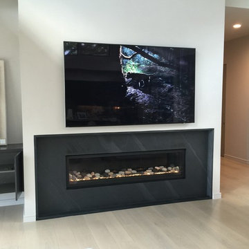 Modern living room TV install over granit blade fireplace