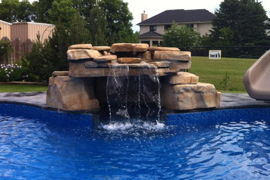 Example of a mid-sized classic backyard lap pool fountain design in Other