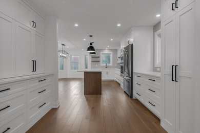 Large transitional dark wood floor and brown floor kitchen pantry photo in Baltimore with shaker cabinets, white cabinets, granite countertops, an island, white countertops, gray backsplash, ceramic backsplash and stainless steel appliances