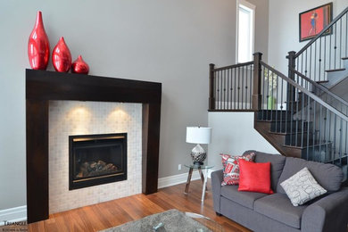 Example of a mid-sized transitional living room design in Ottawa with gray walls, a standard fireplace, a tile fireplace and no tv