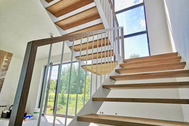 Imagen de escalera en U tradicional de tamaño medio con escalones de madera, contrahuellas de madera y barandilla de metal